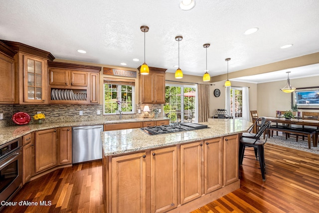 5570 E Shoreline Dr, Post Falls, ID 83854 - kitchen with stainless steel appliances, dark wood-style flooring, brown cabinets, recessed lighting, and a textured ceiling