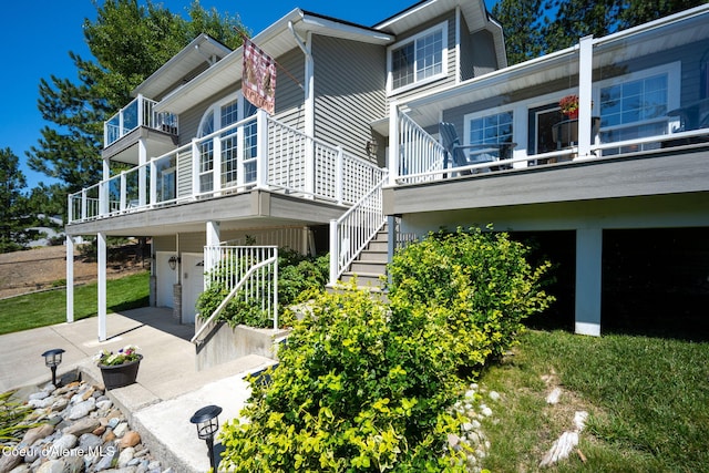5570 E Shoreline Dr, Post Falls, ID 83854 - view of property exterior featuring a garage, concrete driveway, stairway, and a balcony