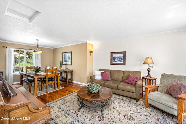 5570 E Shoreline Dr, Post Falls, ID 83854 - living area with wood finished floors, a textured ceiling, crown molding, and attic access