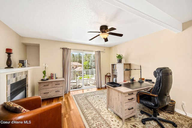 5570 E Shoreline Dr, Post Falls, ID 83854 - office area with light wood-style floors, a ceiling fan, and a tiled fireplace