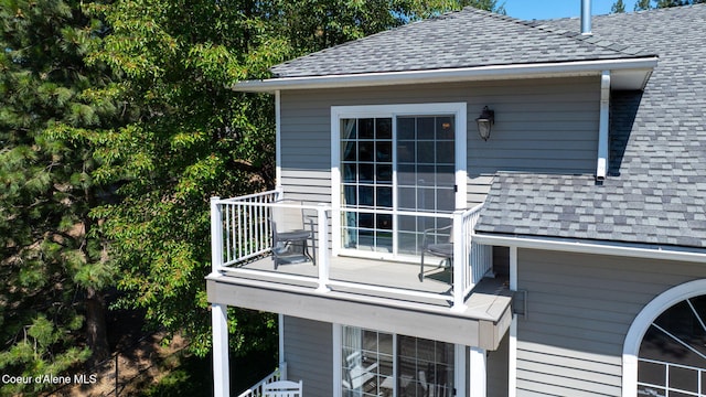 5570 E Shoreline Dr, Post Falls, ID 83854 - view of side of property with a shingled roof and a balcony
