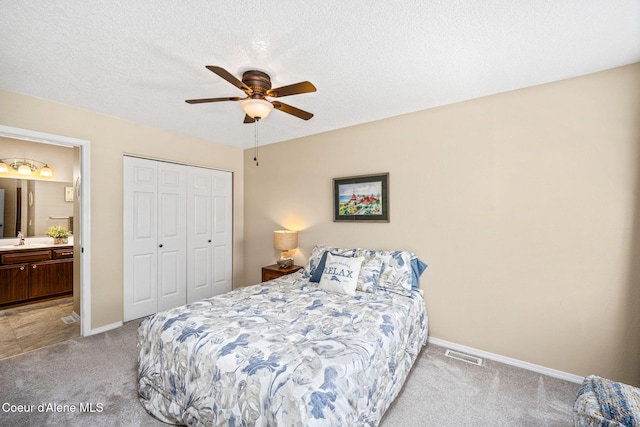 5570 E Shoreline Dr, Post Falls, ID 83854 - bedroom featuring light carpet, a closet, ensuite bathroom, a ceiling fan, and a textured ceiling