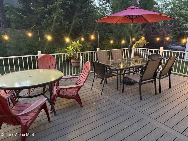 5570 E Shoreline Dr, Post Falls, ID 83854 - wooden terrace featuring outdoor dining area and view of scattered trees