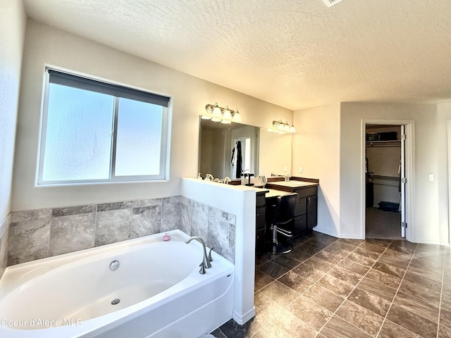 2699 E Thrush Dr, Post Falls, ID 83854 - full bathroom with a garden tub, double vanity, a textured ceiling, and a walk in closet