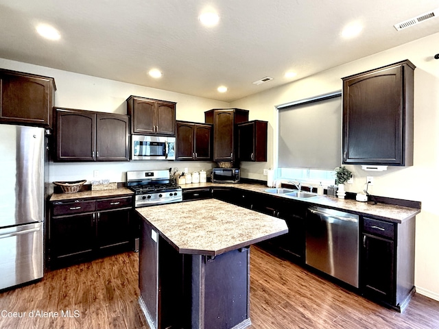 2699 E Thrush Dr, Post Falls, ID 83854 - kitchen featuring appliances with stainless steel finishes, light countertops, a kitchen island, dark wood finished floors, and dark brown cabinetry