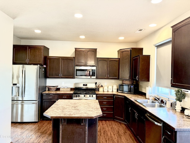 2699 E Thrush Dr, Post Falls, ID 83854 - kitchen featuring appliances with stainless steel finishes, dark brown cabinets, dark wood finished floors, light countertops, and a kitchen island