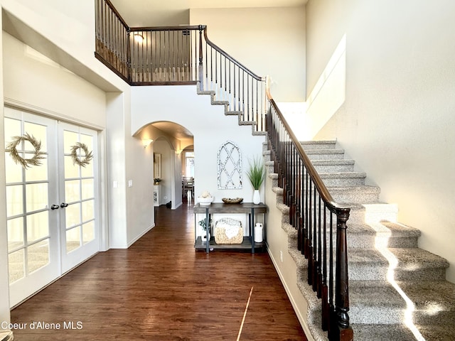 2699 E Thrush Dr, Post Falls, ID 83854 - staircase featuring arched walkways, wood finished floors, a high ceiling, and french doors