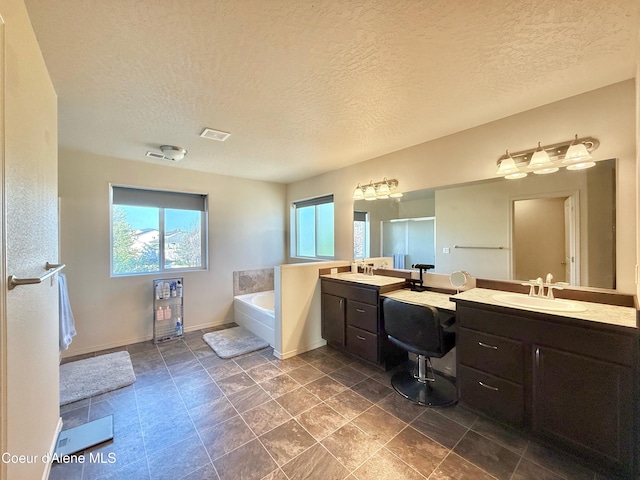 2699 E Thrush Dr, Post Falls, ID 83854 - full bathroom with healthy amount of natural light, a textured ceiling, a bath, and two vanities