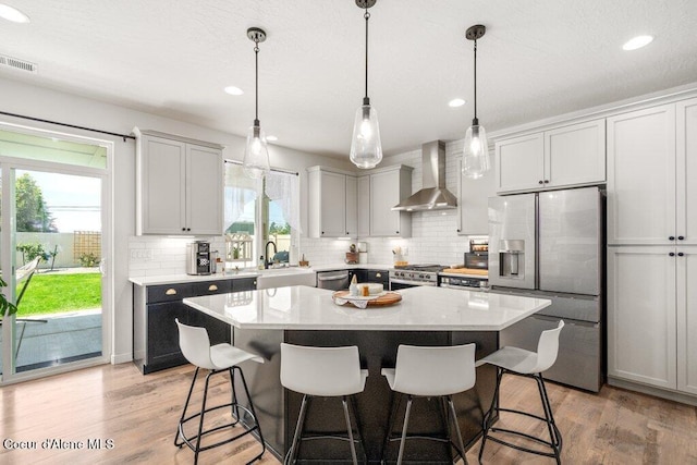 1839 N Skagit Dr, Post Falls, ID 83854 - kitchen featuring wall chimney range hood, stainless steel appliances, healthy amount of natural light, decorative backsplash, and recessed lighting