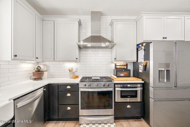 1839 N Skagit Dr, Post Falls, ID 83854 - kitchen featuring appliances with stainless steel finishes, wall chimney exhaust hood, light countertops, and backsplash