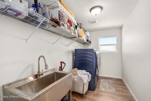 1839 N Skagit Dr, Post Falls, ID 83854 - washroom with washing machine and clothes dryer, wood finished floors, and a textured ceiling
