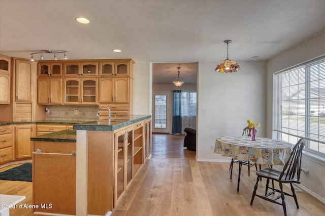 3789 N Steven Pl, Coeur Dalene, ID 83815 - kitchen with dark countertops, light wood-type flooring, glass insert cabinets, backsplash, and recessed lighting