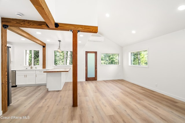 28729 Ramsey Rd, Athol, ID 83801 - unfurnished living room with beamed ceiling, recessed lighting, light wood-style flooring, and a wall unit AC