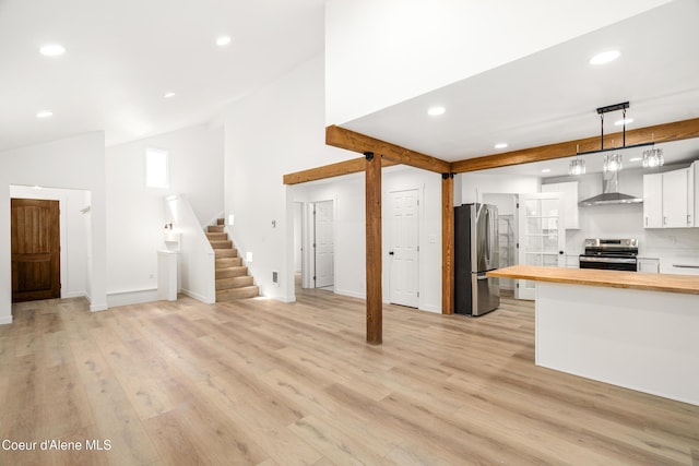 28729 Ramsey Rd, Athol, ID 83801 - kitchen with wood counters, appliances with stainless steel finishes, vaulted ceiling, wall chimney exhaust hood, and white cabinetry