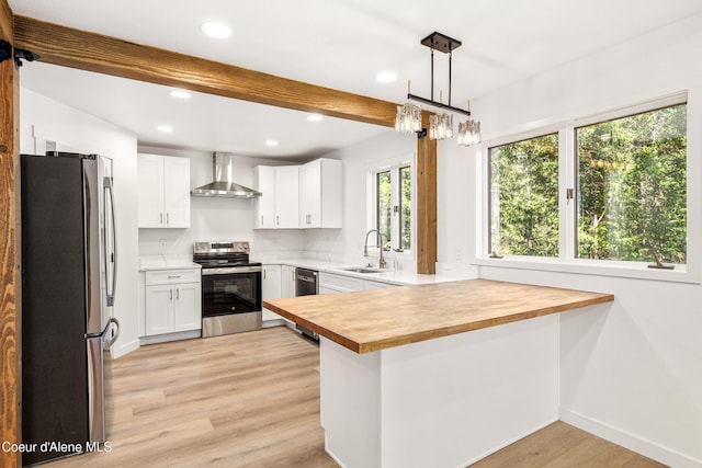28729 Ramsey Rd, Athol, ID 83801 - kitchen with stainless steel appliances, wall chimney range hood, a peninsula, recessed lighting, and light wood finished floors