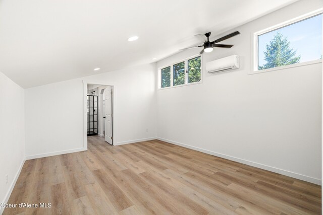 28729 Ramsey Rd, Athol, ID 83801 - empty room featuring an AC wall unit, ceiling fan, light wood finished floors, recessed lighting, and lofted ceiling