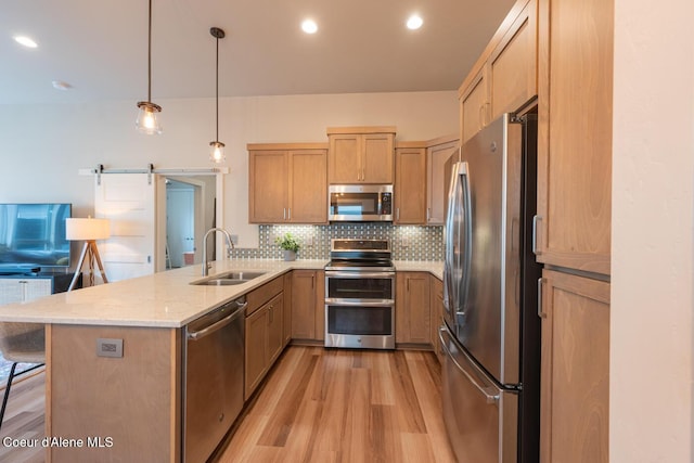 3304 N Rosalia Rd, Coeur Dalene, ID 83814 - kitchen featuring stainless steel appliances, light wood finished floors, a peninsula, backsplash, and light stone counters