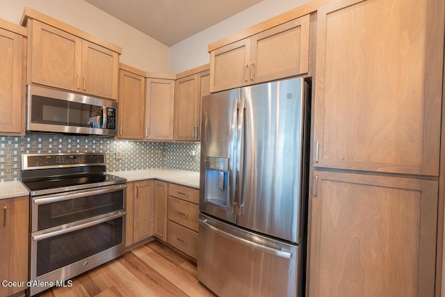 3304 N Rosalia Rd, Coeur Dalene, ID 83814 - kitchen featuring appliances with stainless steel finishes, light countertops, light wood-style floors, tasteful backsplash, and light brown cabinets