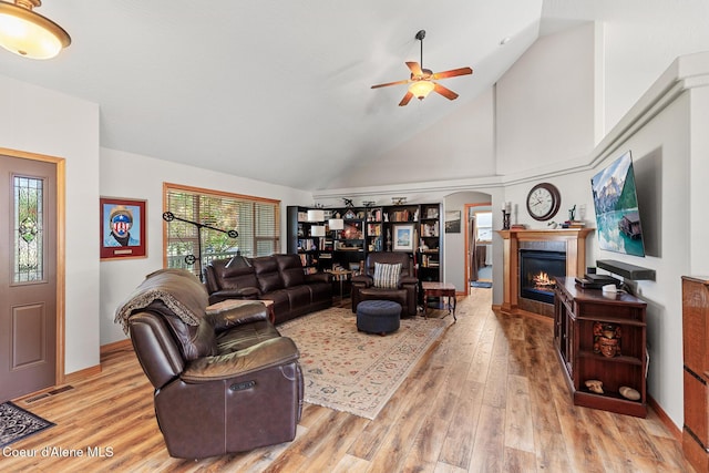 2042 W Heavenly Star Ct, Post Falls, ID 83854 - living area with light wood-style flooring, a ceiling fan, a glass covered fireplace, and high vaulted ceiling