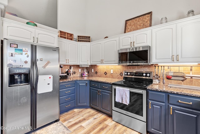 2042 W Heavenly Star Ct, Post Falls, ID 83854 - kitchen featuring appliances with stainless steel finishes, blue cabinets, white cabinets, and tasteful backsplash