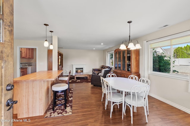 2042 W Heavenly Star Ct, Post Falls, ID 83854 - dining room with independent washer and dryer, wood finished floors, a glass covered fireplace, and plenty of natural light