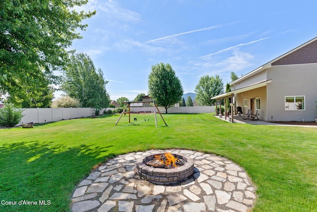 2042 W Heavenly Star Ct, Post Falls, ID 83854 - fenced backyard with an outdoor fire pit, a patio, and a playground