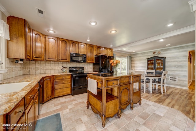 7485 E Revilo Point Rd, Hayden, ID 83835 - kitchen featuring black appliances, ornamental molding, brown cabinetry, tasteful backsplash, and recessed lighting