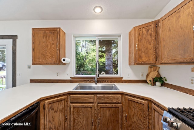 7386 W Sunrise Ct, Rathdrum, ID 83858 - kitchen with dishwasher, light countertops, stove, and brown cabinets
