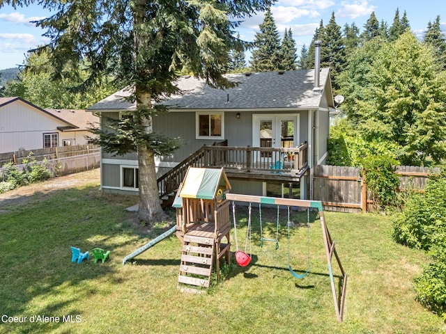 7386 W Sunrise Ct, Rathdrum, ID 83858 - rear view of house featuring a playground, a wooden deck, a fenced backyard, and a shingled roof
