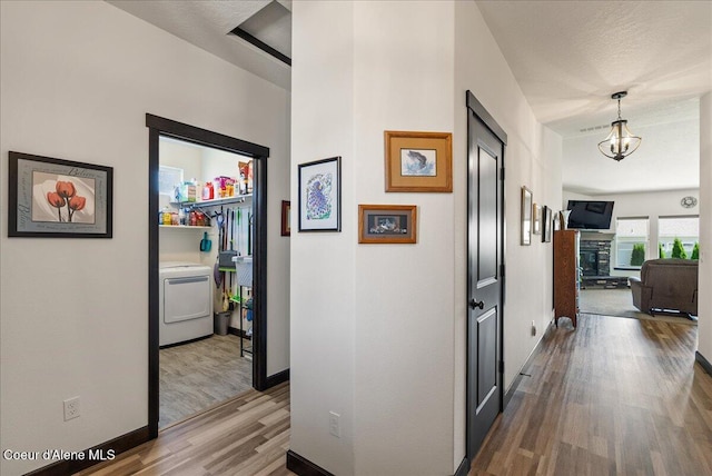 2636 N Wrenley Ln, Post Falls, ID 83854 - hall with wood finished floors, washer / clothes dryer, and a chandelier