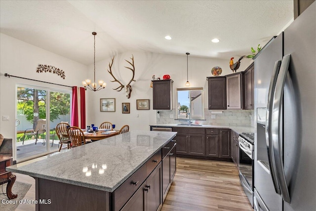 2636 N Wrenley Ln, Post Falls, ID 83854 - kitchen with stainless steel appliances, vaulted ceiling, light wood-style floors, backsplash, and a chandelier