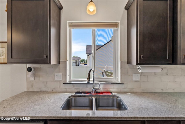 2636 N Wrenley Ln, Post Falls, ID 83854 - kitchen with dark brown cabinetry, backsplash, and light stone countertops
