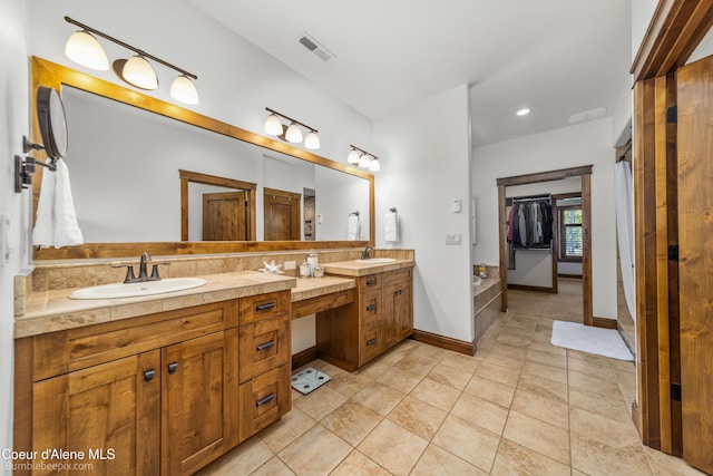 12500 N Partridge Way, Hayden, ID 83835 - bathroom featuring double vanity, a spacious closet, recessed lighting, and tile patterned floors