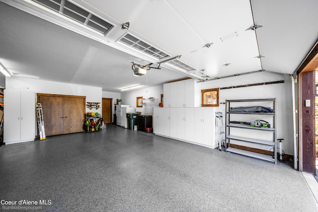 12500 N Partridge Way, Hayden, ID 83835 - garage with freestanding refrigerator and a garage door opener