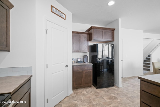 21714 S Lakeview Dr, Worley, ID 83876 - kitchen with freestanding refrigerator, dark brown cabinets, stove, recessed lighting, and stone finish flooring