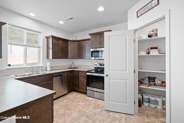 21714 S Lakeview Dr, Worley, ID 83876 - kitchen featuring appliances with stainless steel finishes, dark brown cabinets, recessed lighting, light countertops, and stone finish floors