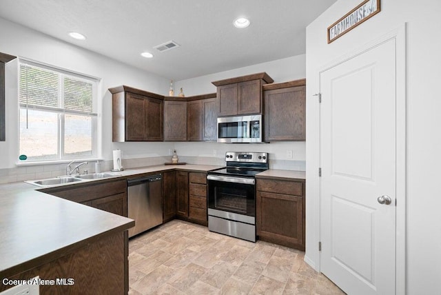 21714 S Lakeview Dr, Worley, ID 83876 - kitchen featuring appliances with stainless steel finishes, dark brown cabinets, recessed lighting, light countertops, and stone finish flooring