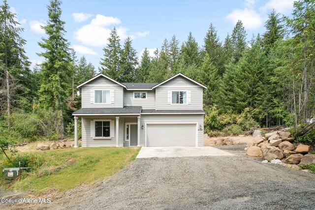 21714 S Lakeview Dr, Worley, ID 83876 - traditional home featuring a garage, driveway, a shingled roof, and a porch