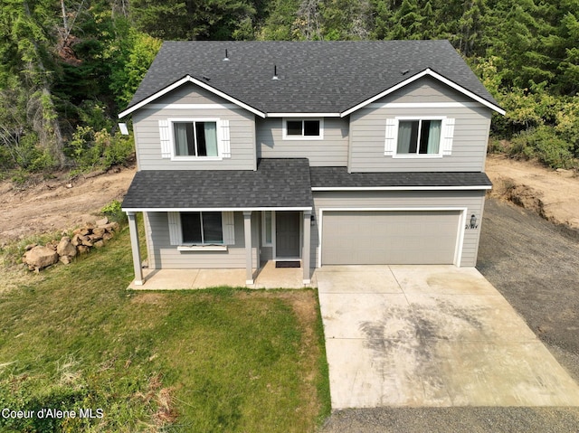 21714 S Lakeview Dr, Worley, ID 83876 - traditional home with roof with shingles, an attached garage, covered porch, concrete driveway, and a front lawn