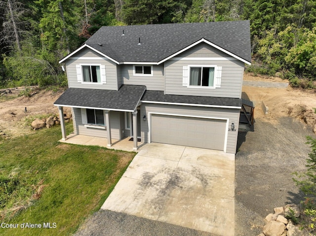 21714 S Lakeview Dr, Worley, ID 83876 - traditional home featuring roof with shingles, a porch, an attached garage, driveway, and a front lawn