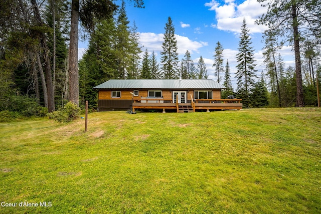 215 Gordon Dr, Priest Lake, ID 83856 - back of house with a deck, a lawn, a metal roof, and a wooded view