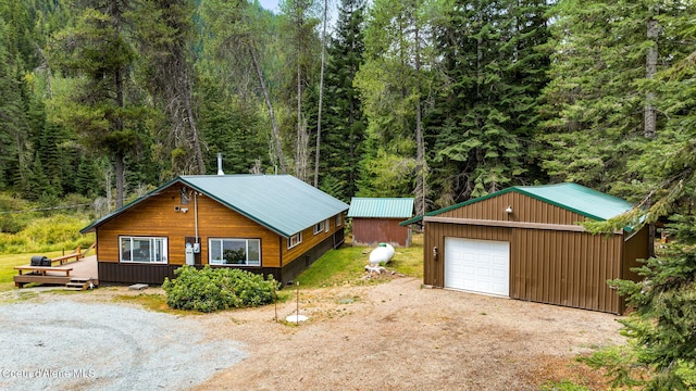 215 Gordon Dr, Priest Lake, ID 83856 - view of side of property with a wooded view, an outbuilding, dirt driveway, and a detached garage
