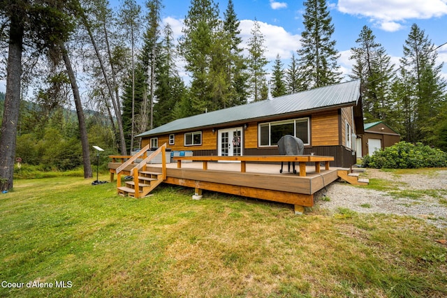 215 Gordon Dr, Priest Lake, ID 83856 - back of property with french doors, a lawn, a deck, and a metal roof