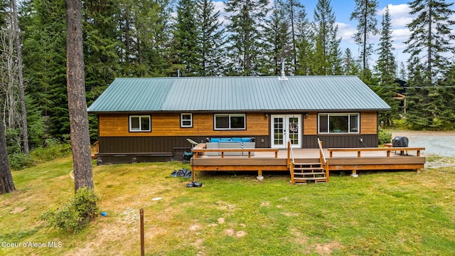 215 Gordon Dr, Priest Lake, ID 83856 - rear view of house featuring french doors, a lawn, a deck, and a metal roof
