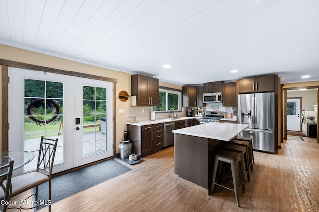 215 Gordon Dr, Priest Lake, ID 83856 - kitchen with appliances with stainless steel finishes, french doors, dark brown cabinetry, light countertops, and a breakfast bar
