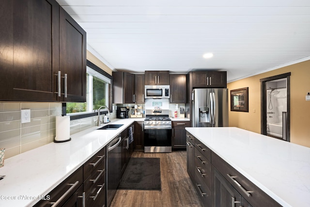 215 Gordon Dr, Priest Lake, ID 83856 - kitchen with stainless steel appliances, dark wood finished floors, light countertops, dark brown cabinets, and ornamental molding