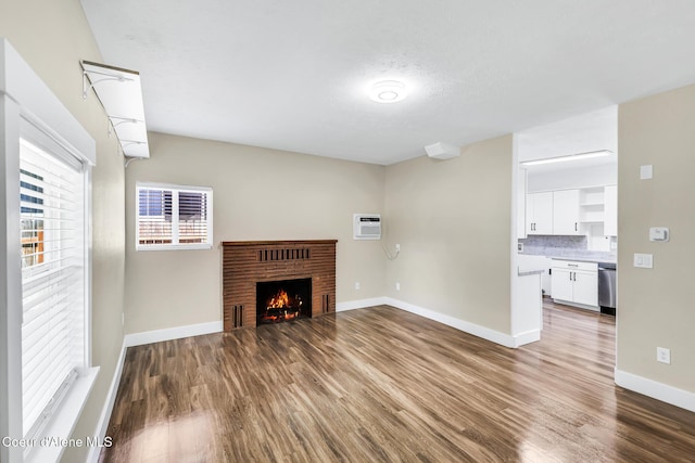 4204 N Jefferson St, Spokane, WA 99205 - unfurnished living room with wood finished floors, an AC wall unit, and a brick fireplace