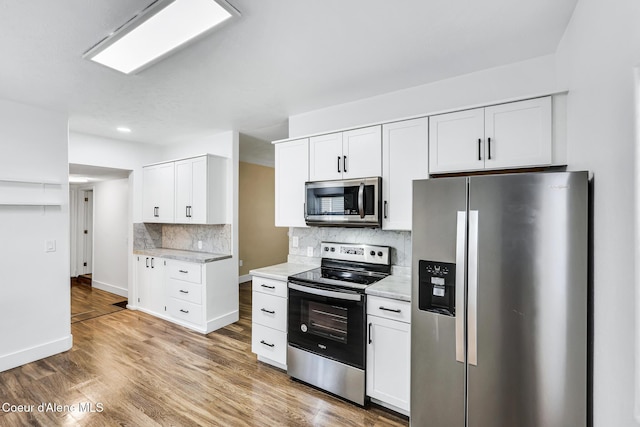 4204 N Jefferson St, Spokane, WA 99205 - kitchen featuring appliances with stainless steel finishes, light countertops, decorative backsplash, white cabinets, and light wood-style flooring