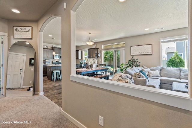 4483 N Connery Loop, Post Falls, ID 83854 - carpeted living room featuring arched walkways, recessed lighting, and a textured ceiling