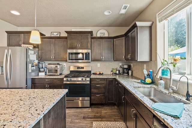 4483 N Connery Loop, Post Falls, ID 83854 - kitchen featuring stainless steel appliances, dark brown cabinetry, dark wood finished floors, tasteful backsplash, and recessed lighting